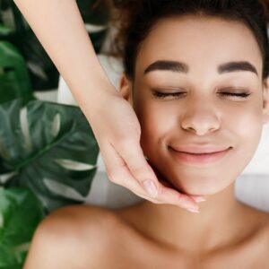 African-american woman enjoying face massage, top view